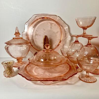 LOT 69: Large Selection of Pink Depression Glass Including Raised Platters, Covered Bowl, Candy Dish with Lid, Stemmed Glassed and Tooth...