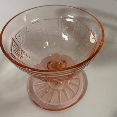 LOT 69: Large Selection of Pink Depression Glass Including Raised Platters, Covered Bowl, Candy Dish with Lid, Stemmed Glassed and Tooth...