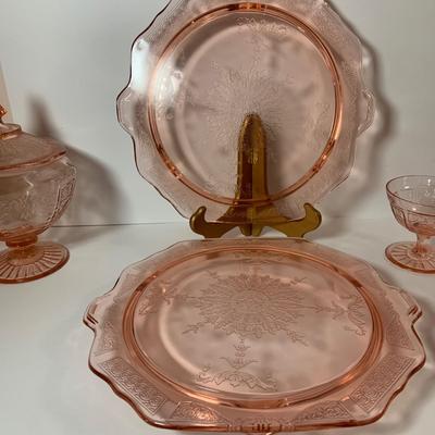 LOT 69: Large Selection of Pink Depression Glass Including Raised Platters, Covered Bowl, Candy Dish with Lid, Stemmed Glassed and Tooth...