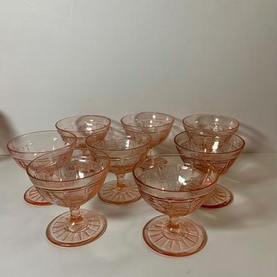 LOT 69: Large Selection of Pink Depression Glass Including Raised Platters, Covered Bowl, Candy Dish with Lid, Stemmed Glassed and Tooth...