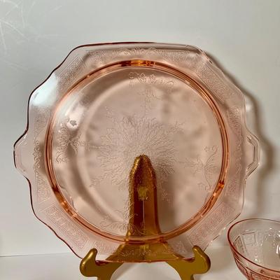 LOT 69: Large Selection of Pink Depression Glass Including Raised Platters, Covered Bowl, Candy Dish with Lid, Stemmed Glassed and Tooth...