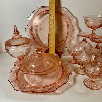 LOT 69: Large Selection of Pink Depression Glass Including Raised Platters, Covered Bowl, Candy Dish with Lid, Stemmed Glassed and Tooth...