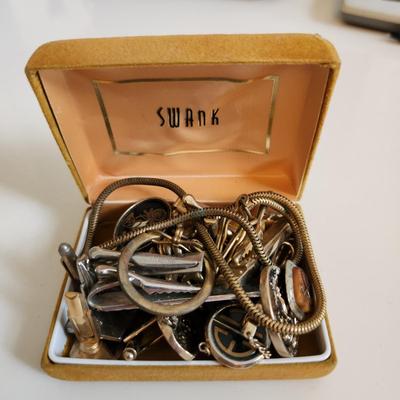 Sale Photo Thumbnail #213: This auction lot is for a Swank Box of Men's Jewelry. This item has all types of men's jewelry.  There is a brass railroad-type watch fog, several tie tack, pins and bars, a nice collection of cuff links - some with trains and other with musical motifs. I