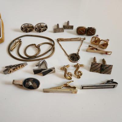 Sale Photo Thumbnail #222: This auction lot is for a Swank Box of Men's Jewelry. This item has all types of men's jewelry.  There is a brass railroad-type watch fog, several tie tack, pins and bars, a nice collection of cuff links - some with trains and other with musical motifs. I