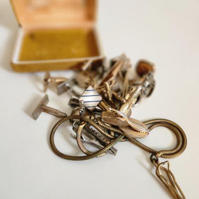 Sale Photo Thumbnail #214: This auction lot is for a Swank Box of Men's Jewelry. This item has all types of men's jewelry.  There is a brass railroad-type watch fog, several tie tack, pins and bars, a nice collection of cuff links - some with trains and other with musical motifs. I