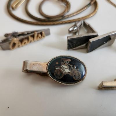 Sale Photo Thumbnail #216: This auction lot is for a Swank Box of Men's Jewelry. This item has all types of men's jewelry.  There is a brass railroad-type watch fog, several tie tack, pins and bars, a nice collection of cuff links - some with trains and other with musical motifs. I