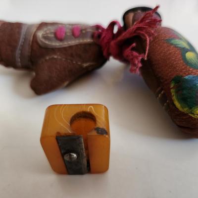 Sale Photo Thumbnail #249: This fun little lot is for a Vintage Trio of Memories.  There is a glass boat candy container, a pair of souvenir miniature boxing gloves from a visit to St. Augustine, Florida and a really cool celluloid pencil sharpener from another era.  Where you gonn