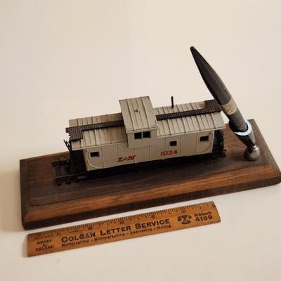 Sale Photo Thumbnail #344: This auction lot is for an L&N Caboose Pen Stand.  This unique desk accessory will look great in the office of any railroad enthusiast.  The pen has some wear and does not write.  The caboose is plastic and it is mounted on a wood base.  See photo for siz