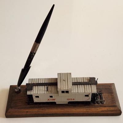 Sale Photo Thumbnail #340: This auction lot is for an L&N Caboose Pen Stand.  This unique desk accessory will look great in the office of any railroad enthusiast.  The pen has some wear and does not write.  The caboose is plastic and it is mounted on a wood base.  See photo for siz