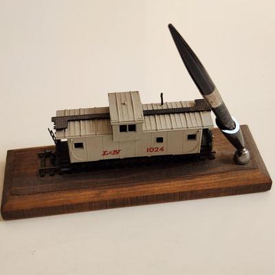 Sale Photo Thumbnail #343: This auction lot is for an L&N Caboose Pen Stand.  This unique desk accessory will look great in the office of any railroad enthusiast.  The pen has some wear and does not write.  The caboose is plastic and it is mounted on a wood base.  See photo for siz