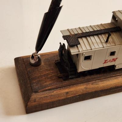 Sale Photo Thumbnail #341: This auction lot is for an L&N Caboose Pen Stand.  This unique desk accessory will look great in the office of any railroad enthusiast.  The pen has some wear and does not write.  The caboose is plastic and it is mounted on a wood base.  See photo for siz