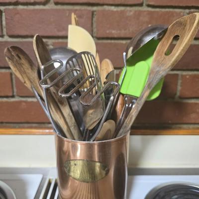 Mixed utensils in copper colored container