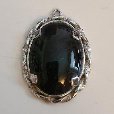 Sale Photo Thumbnail #523: This auction lot is for a Red Vein Jasper Stone Pendant Set in Sterling Silver.  Our resident gem person tells us this stone is either Red Vein Jasper or Black Vein Rhodonite - either way it is a nice stone and with its sterling silver case would look stu