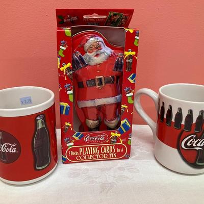 Sale Photo Thumbnail #200: Set of 6 varied Coca-Cola mugs and a Coca-Cola santa tin with playing cards in original box