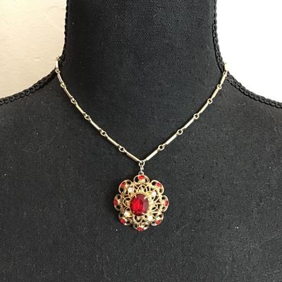 Sale Photo Thumbnail #121: Beautiful, gold tone, vintage choker style necklace with beautiful gold tone, pendant with red rhinestones. Please see attached photos.