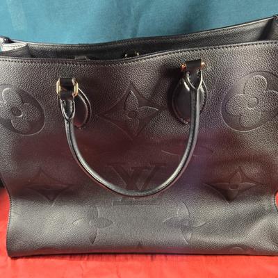 Sale Photo Thumbnail #31: This auction lot is for a Faux Louis Vuitton "On the Go Bag."  It is a quality knock off.  We didn't find any serial numbers inside so we assume it is a fake.  It appears used lightly. Inside is very clean and looks like suede.  There is some light eviden