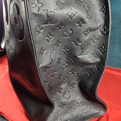 Sale Photo Thumbnail #32: This auction lot is for a Faux Louis Vuitton "On the Go Bag."  It is a quality knock off.  We didn't find any serial numbers inside so we assume it is a fake.  It appears used lightly. Inside is very clean and looks like suede.  There is some light eviden
