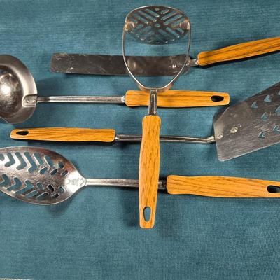 Sale Photo Thumbnail #605: This is a set of 5 Mid Century Modern kitchen utensils.  They are in very good condition for age and use.  The handles are plastic - top is a faux woodgrain, backside is black.  This is a nice addition for your Mid Century Kitchen.