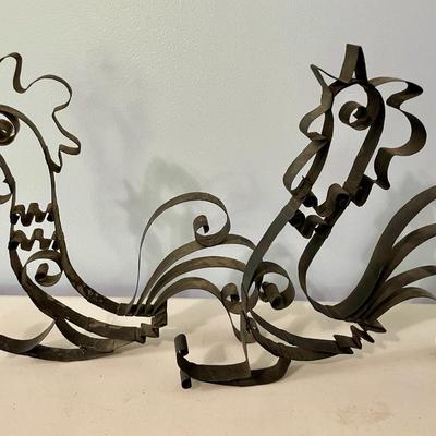 Pair of metal roosters and red metal trivet