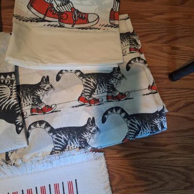 Sale Photo Thumbnail #196: These don't appear to have ever been used however the elastic in both fitted sheets are crumbly and wouldn't work well.  There are two sheet sets, one with the sitting cat and one with the cat wearing red shoes.  Both sets have the pillowcase as cat with 