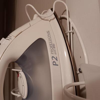 ROWENTA PROFESSIONAL CLOTHES IRON, IRONING BOARD AND A WALL MOUNTED HOLDER