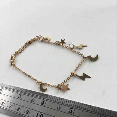Gold tone stars and lightening bolt charm bracelet