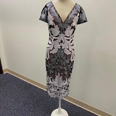 Sale Photo Thumbnail #448: Below Knee length, Gray and silver lace 
Back zip, cream lining
Kick pleat in back., polyester and metallic
Size 4 
Very good condition, 1 original owner