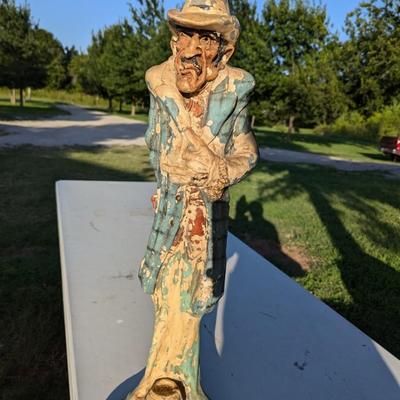 Sale Photo Thumbnail #179: approx 30 inches tall, he's got a card in his hat, he's reaching for a hidden gun and there is a knife hidden in a pocket.  He show a lot of wear from being outside but he is a fun statue to have.