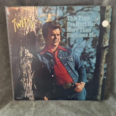 Sale Photo Thumbnail #232: "This Time I've Hurt Her More Than She Loves Me" by Conway Twitty. 
Additional information about the album includes:
Artist: Conway Twitty, a well-known American country music artist.
Album Title: This Time I've Hurt Her More Than She Loves Me.
Release Ye