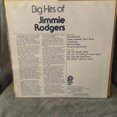 Sale Photo Thumbnail #411: "Big Hits of Jimmie Rodgers". 
Additional details include:
Artist: Jimmie Rodgers, a well-known American singer from the 1950s and 60s.
Format: 12" LP (33 RPM vinyl record).
Record Label: Pickwick (also known as Pickwick/33 Records). The specific release 