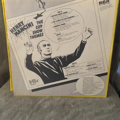 Sale Photo Thumbnail #413: The Cop Show Themes" by Henry Mancini. 
Here's what you might like to know about this record:
Artist: Henry Mancini, a renowned American composer, conductor, and arranger famous for film scores like The Pink Panther and Breakfast at Tiffany's.
Album Title