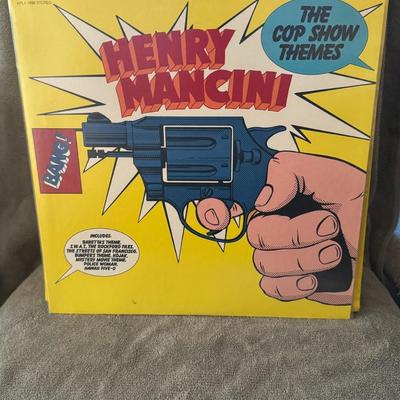 Sale Photo Thumbnail #412: The Cop Show Themes" by Henry Mancini. 
Here's what you might like to know about this record:
Artist: Henry Mancini, a renowned American composer, conductor, and arranger famous for film scores like The Pink Panther and Breakfast at Tiffany's.
Album Title