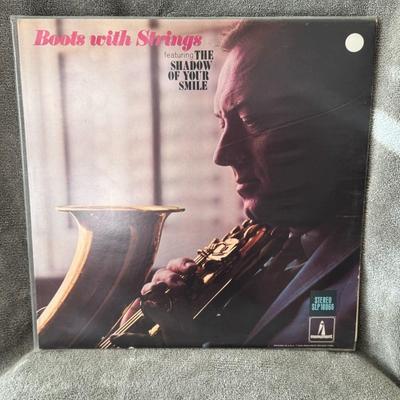 Sale Photo Thumbnail #304: "Boots with Strings" by Boots Randolph, released in 1966 on Monument Records. 
This classic instrumental album showcases Boots Randolph's signature saxophone playing, notably featuring the popular song "The Shadow of Your Smile". The album's tracklist inc