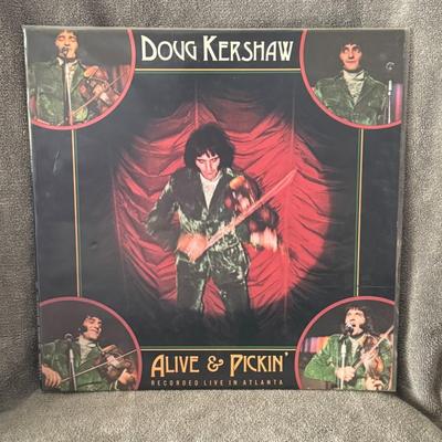 Sale Photo Thumbnail #320: Alive & Pickin' by Doug Kershaw. 
Here's some information about the album:
Artist: Doug Kershaw, a renowned Cajun fiddler and musician.
Album Title: Alive & Pickin'.
Release Year: 1975.
Label: Warner Bros. Records.
Format: 12" Vinyl LP (Long Play) record.