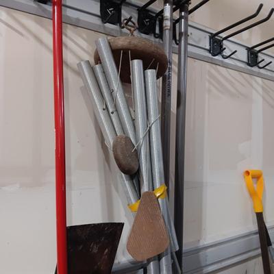 LARGE WIND CHIME, PUSH BROOM, SNOW SHOVEL, POST HOLE DIGGER, SHOVEL AND SOME ICE MELT