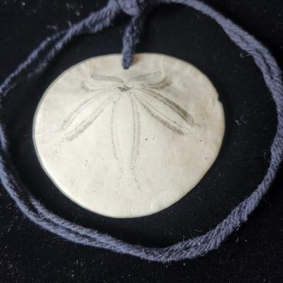 Sale Photo Thumbnail #606: 3 inch diameter sand dollar, 26 inch cord.
Retail at $115.00