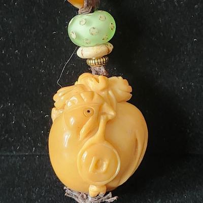 Sale Photo Thumbnail #613: Pendant only.  carved Tague Nut, (Japanese) , called vegetable ivory
3.5 inches long 
What a fun piece to wear
