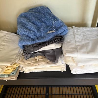 Group of bed linens, mostly pillow cases