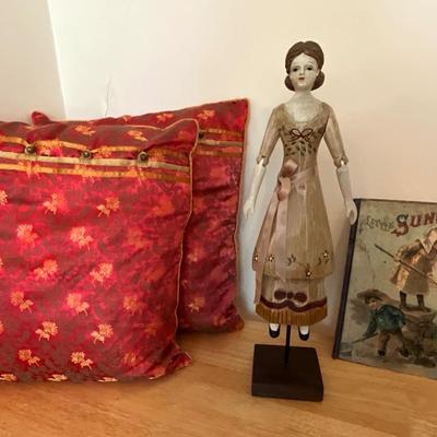 Wooden carved doll, very old children’s book, pillows