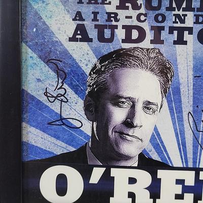 LOT 87: Autographed Framed "The Rumble in the Air-Conditioned Auditorium" Poster Autographed by Jon Stewart and Bill O'Reilly