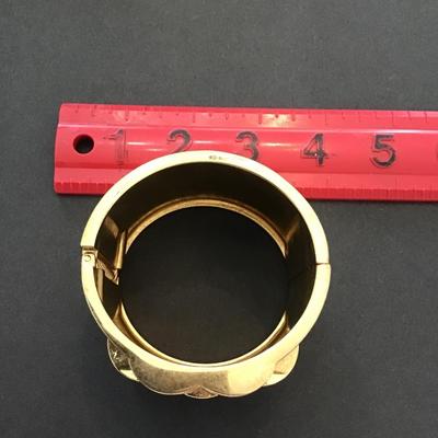 Gold tone, hinged bracelet with rhinestones