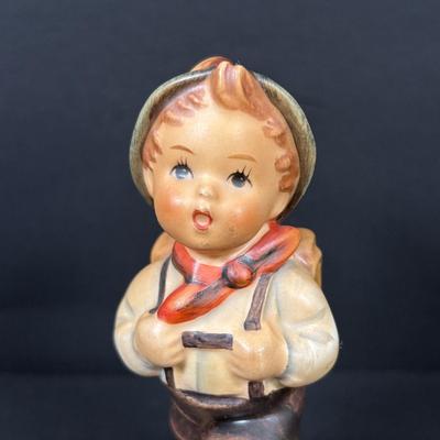 LOT 99: Set of 2 Hummels: Blessed Event & School Boy along with a Napco The Singer Figure