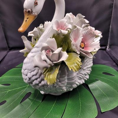 Sale Photo Thumbnail #657: 12.5 x 12.5 inches, #G706
Heavily flowered swan. There is damage to one flower , one petal is chipped off.  
Very beautiful piece of porcelain 
Fair condition
Retails $125 to $425