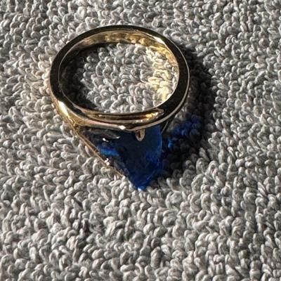 Ring with a prominent blue stone and a yellow gold-toned band.