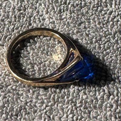 Ring with a prominent blue stone and a yellow gold-toned band.
