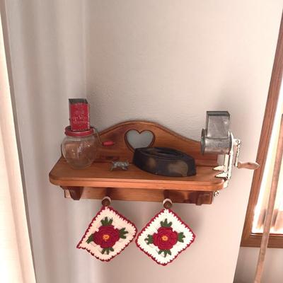 WOODEN WALL SHELF, 2 HAND CRANKED GRINDERS, CAST CLOTHES IRON, PEWTER PIG AND 2 HANDMADE POT HOLDERS