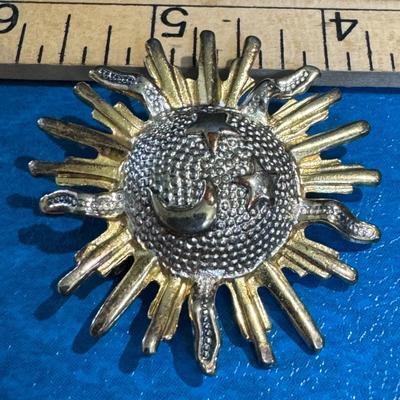 Sun-shaped brooch, sunburst or celestial pin.