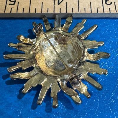 Sun-shaped brooch, sunburst or celestial pin.