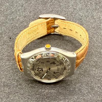 Sale Photo Thumbnail #297: Larger numbers 12, 7, and 7 are printed backwards on the dial.  Silver tone case with brown leather band. Not running, most likely needs a new battery.