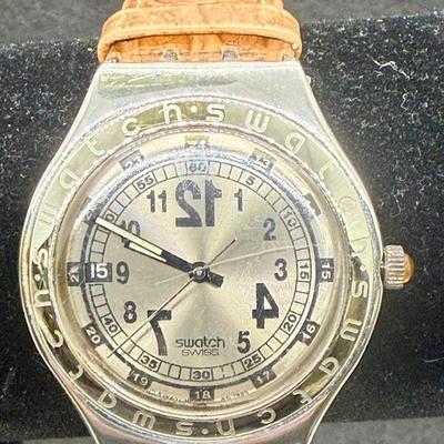 Sale Photo Thumbnail #295: Larger numbers 12, 7, and 7 are printed backwards on the dial.  Silver tone case with brown leather band. Not running, most likely needs a new battery.